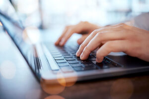 Hands typing on laptop