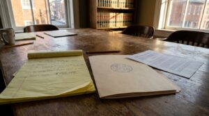 legal notepad with $965,000 case notes beside official sealed court document on law office table